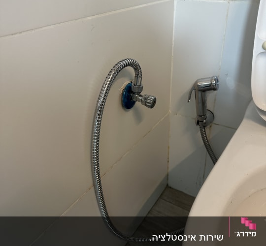 צינור מתכת מחובר לשירותים עם ברז קטן